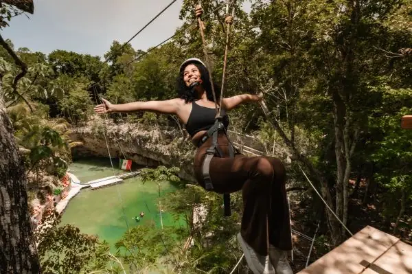 Woman on a zipline over a cenote